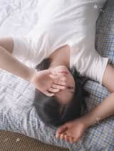 一位二十多岁的年轻东亚女性，黑色长发随意扎成低马尾