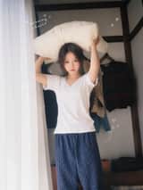 一位二十多岁的年轻东亚女性，黑色长发随意扎成低马尾