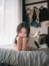 一位二十多岁的年轻东亚女性，黑色长发随意扎成低马尾