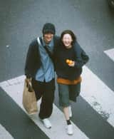 A cinematic overhead street photo of a young couple walking
