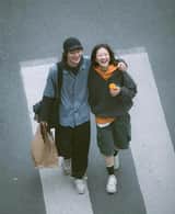 A cinematic overhead street photo of a young couple walking