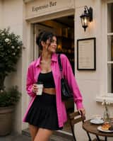 A fashionable young woman stands casually outside an elegant