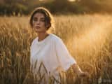 Warm golden hour film portrait, young woman walking slowly