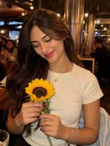 Mujer con un girasol en un cálido entorno de restaurante