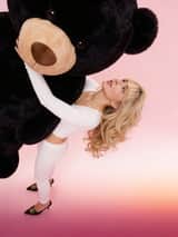 Retrato Glamouroso Y2K de Sabrina Carpenter com Urso de Pelúcia Gigante