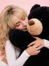 Retrato Glamouroso Y2K de Sabrina Carpenter com Urso de Pelúcia Gigante