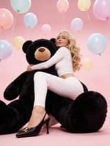 Retrato Glamouroso Y2K de Sabrina Carpenter com Urso de Pelúcia Gigante