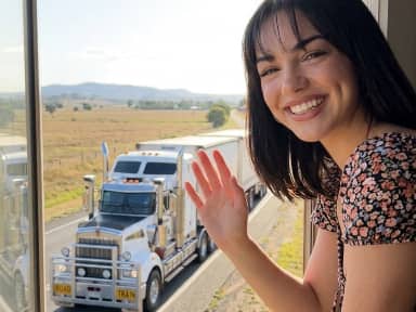 Donna che saluta un semirimorchio su un'autostrada rurale