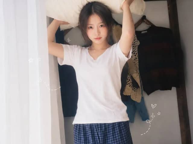 一位二十多岁的年轻东亚女性,黑色长发随意扎成低马尾