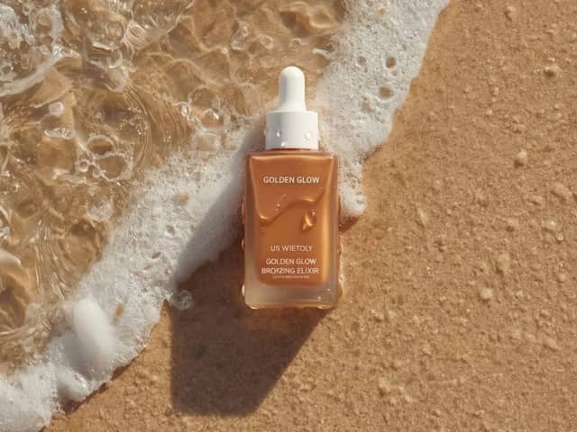 Photographie ultra-réaliste de produits de soin sur du sable de plage humide