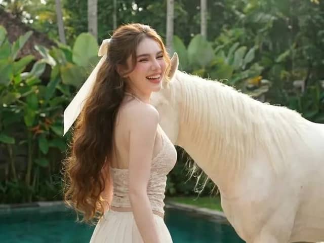 Donna a bordo piscina e cavallo bianco