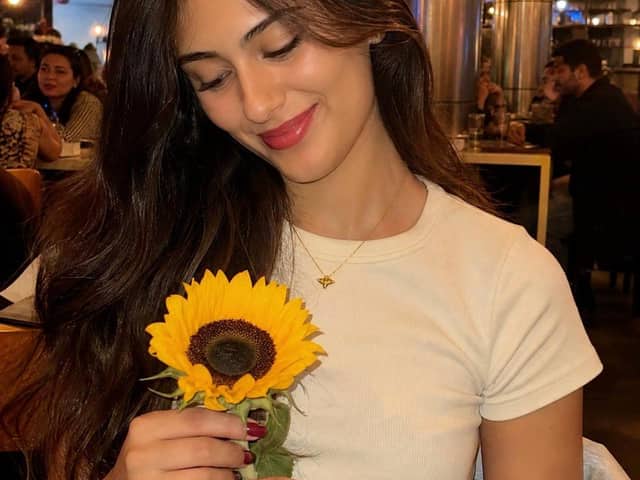 Mujer con un girasol en un cálido entorno de restaurante