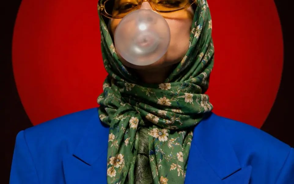 A stylized portrait photograph against a large red circular